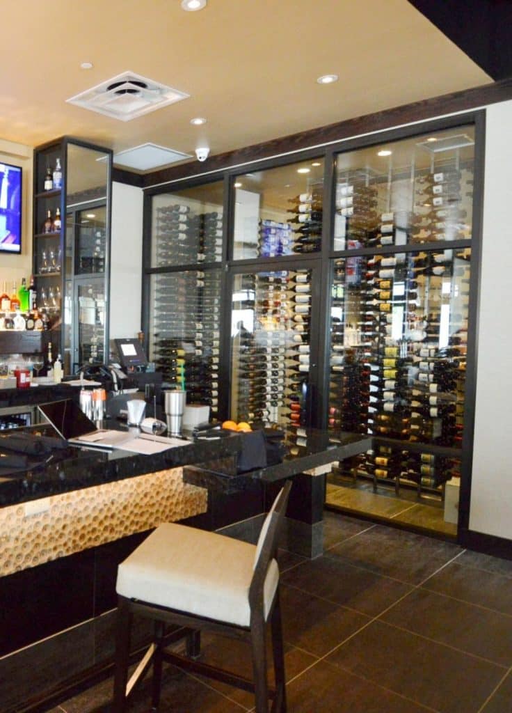 This contemporary commercial custom wine cellar in Orange County, california, displays the wines in metal wine racks.